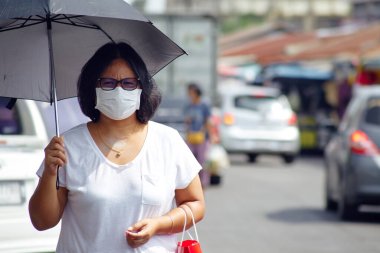 Korona virüsünden korunmak için kalabalık pazar caddelerindeki virüslere karşı korunmak için maskeli Asyalı kadınlarla dolu.