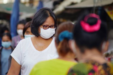 Korona virüsünden korunmak için kalabalık pazar caddelerindeki virüslere karşı korunmak için maskeli Asyalı kadınlarla dolu.