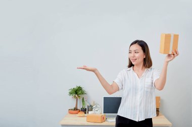 Asyalı kadın paket siparişi tutuyor, ev ofisinde çalışıyor. Çevrimiçi pazarlama dağıtımı, başlangıç KOBİ girişimcisi veya serbest girişimci kavramı