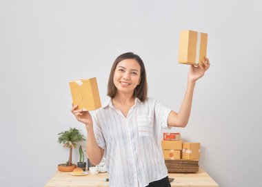 Asyalı kadın paket siparişi tutuyor, ev ofisinde çalışıyor. Çevrimiçi pazarlama dağıtımı, başlangıç KOBİ girişimcisi veya serbest girişimci kavramı