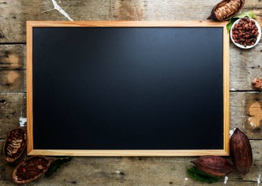 Kuru kakao kabuğu, kakao çekirdeği ve kakao tozu ile ahşap duvar desenli arka planda klasik resim çerçevesi düz, uzay yatağı.