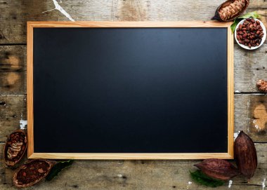 Kuru kakao kabuğu, kakao çekirdeği ve kakao tozu ile ahşap duvar desenli arka planda klasik resim çerçevesi düz, uzay yatağı.