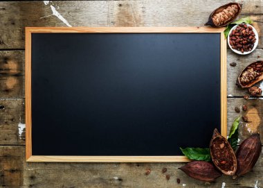 Kuru kakao kabuğu, kakao çekirdeği ve kakao tozu ile ahşap duvar desenli arka planda klasik resim çerçevesi düz, uzay yatağı.