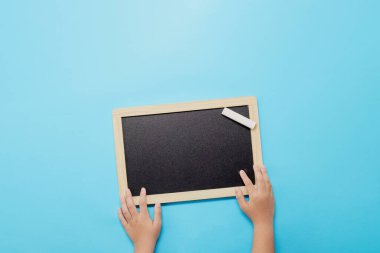 Ellerinde boş tahta ve tebeşirle çocuk elleri okula geri dönüyor.