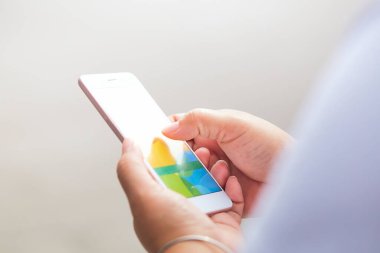 Arka planda, ekrandaki akıllı telefonu işaret eden kadın elleri yakın plan, cep telefonuna mesaj yazan kadın.