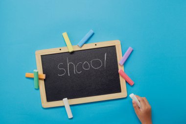 Tahtaya yazı yazan bir kızın yüksek açılı görüntüsü. Okul konseptine dönelim..