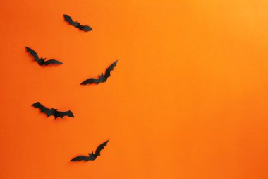 Cadılar Bayramı ve dekorasyon konsepti kağıt yarasalar kağıt turuncu arka planda uçuyor