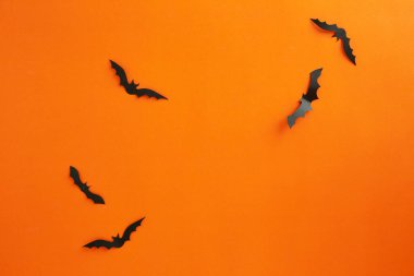 Cadılar Bayramı ve dekorasyon konsepti kağıt yarasalar kağıt turuncu arka planda uçuyor