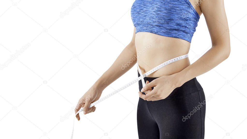 Fit woman measuring her waist using a tape measure