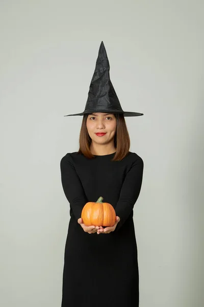 ハロウィーンの休日の背景 若いです可愛いです女性で魔女帽子保持ハロウィンカボチャジャックOランタン装飾 — ストック写真