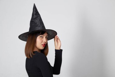 Cadılar Bayramı partisi için cadı kostümü giyen güzel Asyalı kadın.