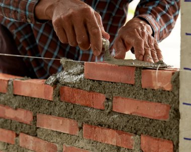 Tuğlacı iş başında. İnşaat alanına tuğla döşeyen endüstriyel tuğlaların kapatılması