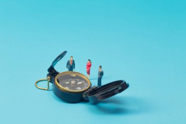 Minyatür işadamı ve pusula parlak mavi sırtüstü