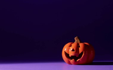 Pastel menekşe arkaplan ve fotokopi alanı üzerine turuncu balkabağı, Cadılar Bayramı arkaplanı, Ekim festivali konsept tatili, tatil partisi, Cadılar Bayramı minimum konsept.