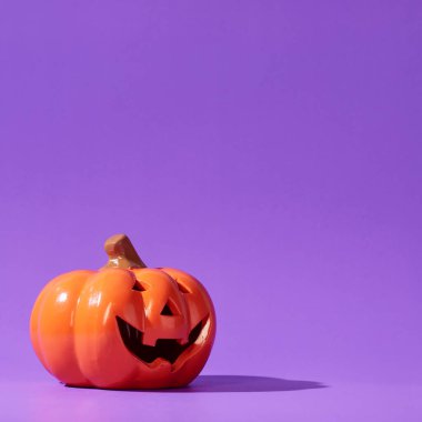 Pastel menekşe arkaplan ve fotokopi alanı üzerine turuncu balkabağı, Cadılar Bayramı arka planı, Cadılar Bayramı minimum konsept.