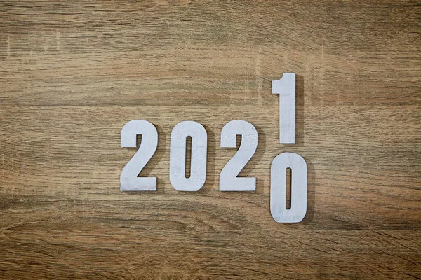 Ahşap masa arkasında ahşap beyaz numara 2021. 2020 'den 2021' e değiştir.