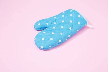 İzole edilmiş pembe arka planda mavi noktalı mutfak eldiveni