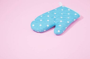 İzole edilmiş pembe arka planda mavi noktalı mutfak eldiveni