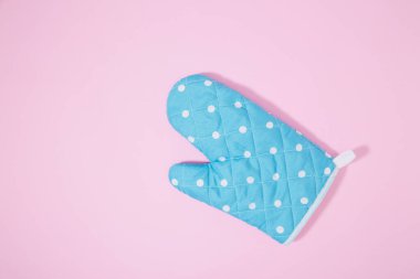 İzole edilmiş pembe arka planda mavi noktalı mutfak eldiveni