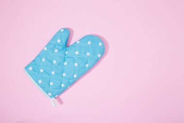 İzole edilmiş pembe arka planda mavi noktalı mutfak eldiveni