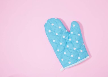 İzole edilmiş pembe arka planda mavi noktalı mutfak eldiveni