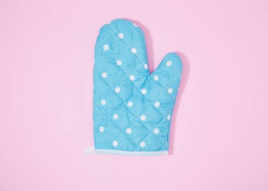 İzole edilmiş pembe arka planda mavi noktalı mutfak eldiveni