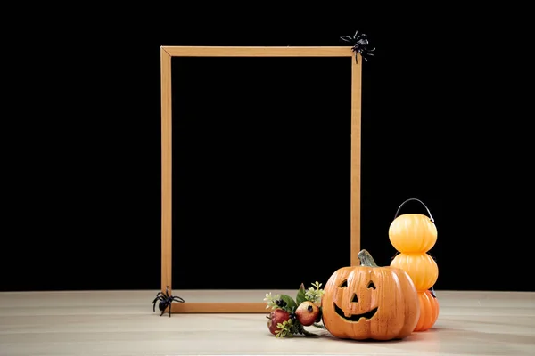 Frame and Jack O Lantern Halloween festival decoration pumpkin with witches hat on wooden table with dark background copy space for text