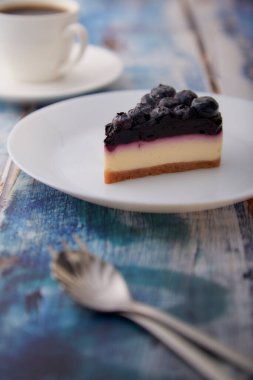 Böğürtlenli kek beyaz tabakta ahşap arka planda