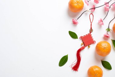 Mutlu Çin Yeni Yılı 2021 ya da Ay Yeni Yıl Dekorasyonu Festivali Üst Görünüm Kolye Süslemeleri Düğüm ve Pembe kirazlı Beyaz Ahşap Masa Üzerinde Turuncu Meyve