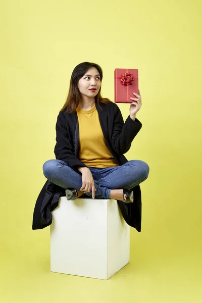 Ευτυχισμένη Ελκυστική Νεαρή Γυναίκα Κάθεται Κενό Κενό Κουτί Κρατώντας Κόκκινο — Φωτογραφία Αρχείου