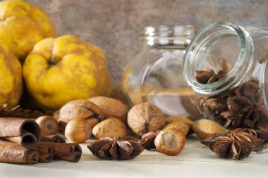 Ayva, ceviz, badem, fındık ve baharatlar ahşap masada.