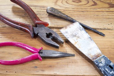 Nippers, tornavida ve palet, ahşap arka planda.