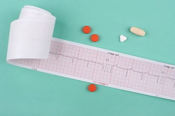 Yeşil arka planda EKG ve haplar
