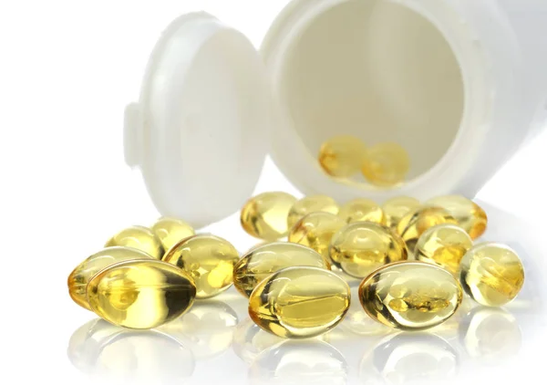 Beyaz arka planda izole edilmiş bir şişeden çıkan omega 3 balık yağı kapsülleri.