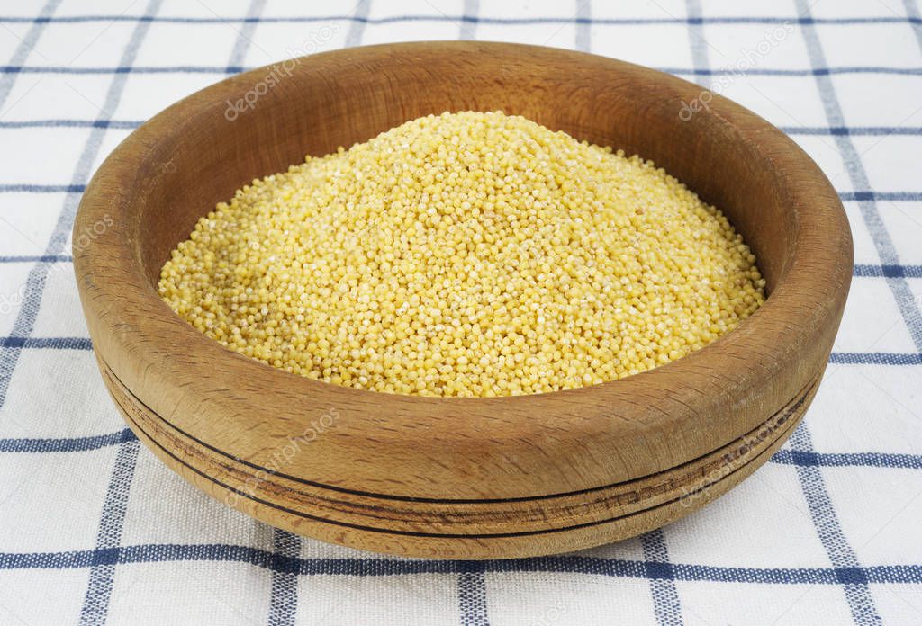 millet in a wooden bowl  on background,close up