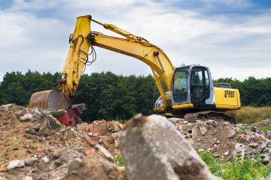 Modern kazıcı depremden sonra bir binanın enkazını temizler.