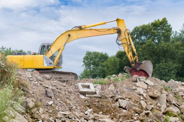 Modern kazıcı depremden sonra bir binanın enkazını temizler.