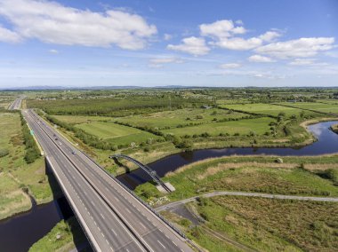 Köprüyü geçtikten bir su Nehri ve demiryolu ennis county clare, İrlanda izlemek ile meşgul bir İrlandalı otoyol görünümünü hava kuşlar göz