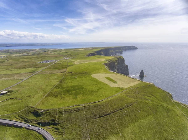 爱尔兰克莱尔县莫赫悬崖的世界著名鸟瞰空中无人机全景 美丽动人的爱尔兰海滨风景在野生大西洋路路线上 地质公园土方车道 图库照片