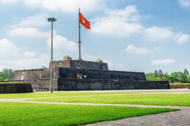 Vietnam (kırmızı bayrak altın bir yıldız ile) bir kule mavi gökyüzü arka plan Hue, Vietnam için üzerinde kalenin içinde çırpınan bayrak. Kalenin içinde ile mor Yasak Şehir İmparatorluk kentidir.