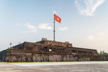 Vietnam (kırmızı bayrak altın bir yıldız ile) bir kule kalenin üzerinde günbatımında Hue, Vietnam içinde çırpınan bayrak doğal görünümünü. Kalenin içinde ile mor Yasak Şehir İmparatorluk kentidir.
