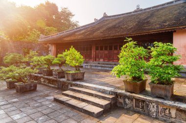 Doğal kırmızı Tu Duc kraliyet mezarı Hue, Vietnam için bina. Binanın yanında büyüyen yeşil Bonsai Ağaçlar. Renk tonu Asya'nın popüler bir turistik yer.