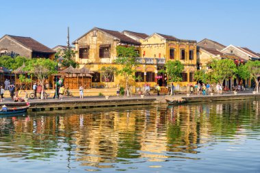 Hoi bir (Hoian), Vietnam - 11 Nisan 2018: Hoi An Antik şehirdeki Prş Bon Nehri'nin su geleneksel sarı bina harika manzarasını yansıtılır. Set yürüyen turist.