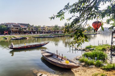 Hoi An antik kenti (Hoian), Vietnam tarih Prş Bon Nehri kıyısında güzel bir ahşap tekne manzarası Park. Vietnam kadın teknede geleneksel bambu şapkalı arka planda görünür.