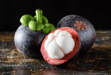 Eski ahşap masa üzerinde closeup görünümü taze Mangosteen. Tatlı beyaz eti ile doğal tropikal meyve. Sağlıklı çevre gıda. Organik Tarım ürün. Taze hasat meyve.