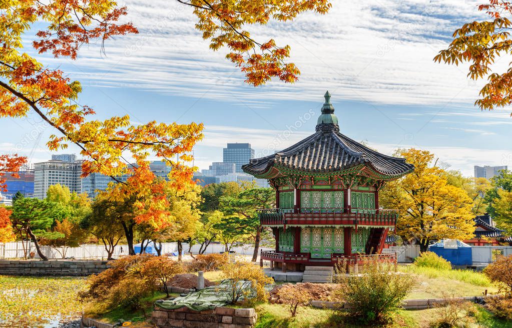 Wonderful view of Hyangwonjeong Pavilion on an artificial island of lake at Gyeongbokgung Palace in Seoul, South Korea. Classical pavilion of traditional Korean architecture. Colorful autumn cityscape