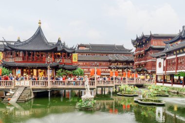 Shanghai, Çin - 5 Ekim 2017: Turist üzerinde gölet Old City Yuyuan Garden Jiuqu köprüden. Geleneksel kırmızı Çin binaların görünümü. Shanghai popüler bir turistik yer.