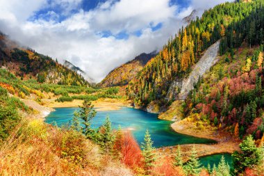Renkli sonbahar woods ve sis, Jiuzhaigou doğa rezerv (Jiuzhai Vadisi Milli Parkı), Çin dağlarında arasında masmavi su ile üst mevsimsel gölün muhteşem görünümü. Doğal güneşli sonbahar manzara.