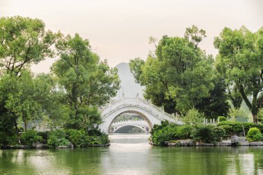 Beyaz ikiz mermer köprü Guilin park Çin yeşil ağaçların arasında göl kenarında güzel bir akşam manzarası. Harika yaz manzara. Guilin Asya'nın popüler bir turistik yer.