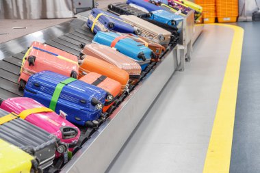 Parlak renkli bavul ve çanta varış alanı Havaalanı-yolcu terminal Bagaj konveyör bant üzerinde. Bagaj atlıkarınca.